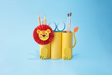 Creative pencil holder shaped like lion using toilet paper roll and scissors, perfect for kids DIY projects, craft branding, homeschool lessons, or eco art content
