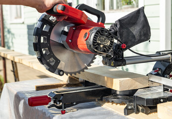 Cuts a wooden beam using a circular saw. Home furniture workshop. Work in his carpentry workshop....