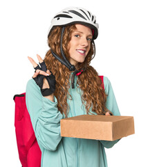 Redhead food delivery in studio joyful and carefree showing a peace symbol with fingers.
