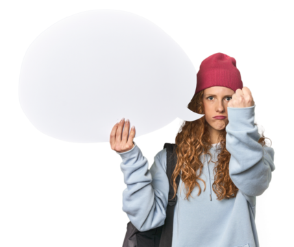 Redhead holding a comic speech bubble showing fist to camera, aggressive facial expression.