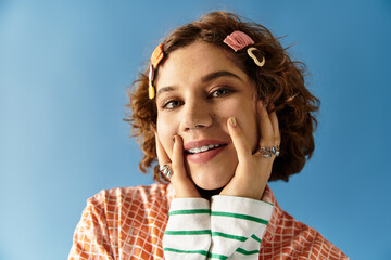 Young woman exudes joy in vibrant outfit against a striking blue background