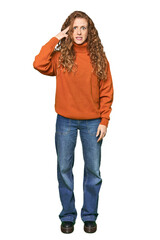Full-body redhead portrait showing a disappointment gesture with forefinger.