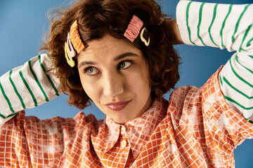 Vibrant summer fashion portrait of a young woman with curly hair on a blue backdrop