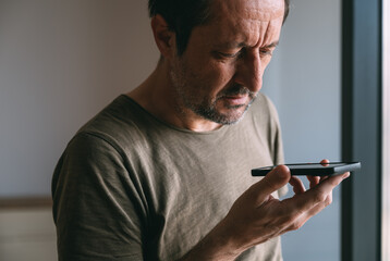 Holding phone in front of face and talking, man talking on mobile phone while holding the device...
