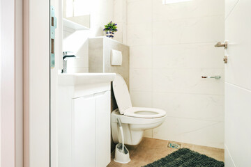 Toilet seat in bathroom with white tiles