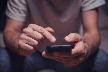 Typing text message on mobile phone, closeup of male hands
