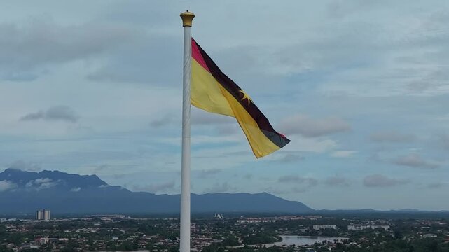 Aerial drone footage Tallest flagpole in Malaysia, and South East Asia. The Tiang Ibu Pertiwi, translated to Pillars of The Motherland, waving Sarawak flag beside Sarawak State building