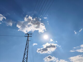 electricity pole, photographed against the sky and clouds.
