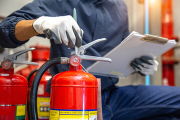 Engineer are checking and inspection a fire extinguishers tank in the fire control room for safety...