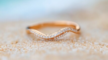 Elegant gold ring with diamonds showcased on sandy beach during daylight
