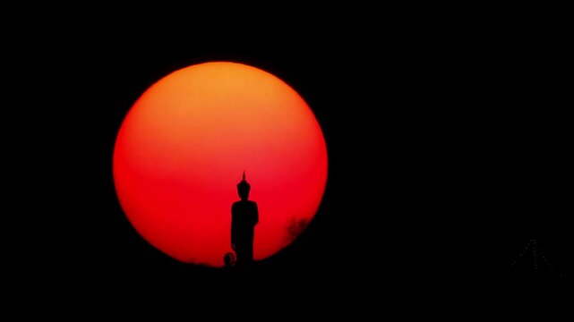 Time lapse of sun setting behind the buddha statue and pine trees on a background Timelapse of dramatic sunset with orange sky in a sunny day. adventure