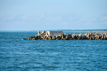 Serene coastal view features concrete tetrapods on breakwater against calm sea, evoking tranquility...
