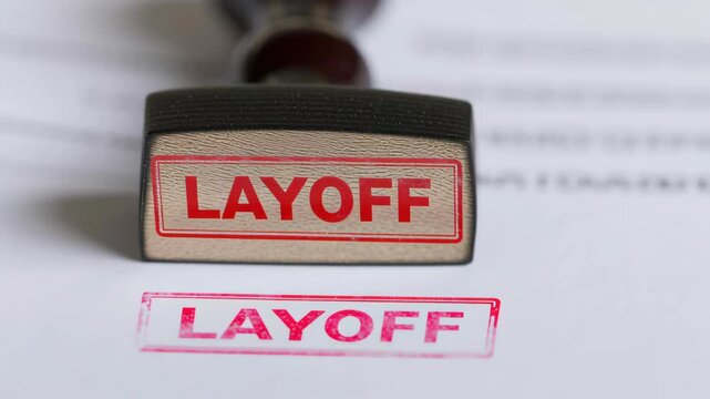 Layoff employee and unemployment concept, Stamp with "LAYOFF" impression on paper documents.