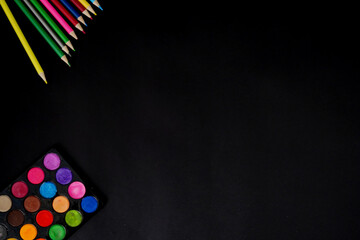 Colored pencils and paints on black background