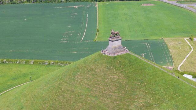displays complete monument visitors top well parking buildings town surrounded by green grass open fields lion's mound waterloo circling aerial drone shot leeuw van belgium 