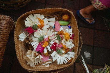 Balinese offerings, called Canang Sari, fill a woven basket. These daily offerings include flowers,...