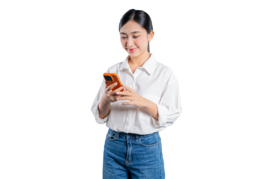 Asian woman in a casual white shirt and jeans smiles pleasantly as she looks down at her smartphone, engrossed in texting or Browse social media against a png background.
