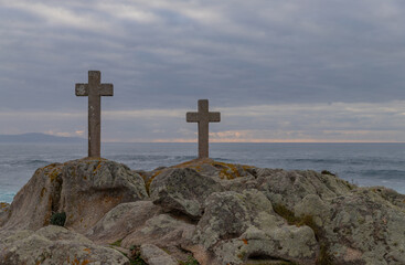 Two stone crosses stand on a rugged cliffside