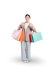A very happy young Asian woman holding shopping bags gives two thumbs up to the camera, expressing her complete satisfaction and enthusiastic approval of her shopping experience.