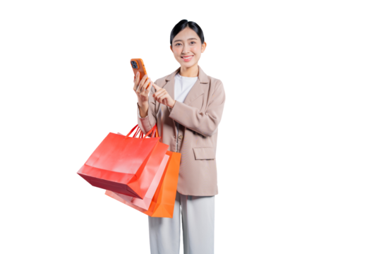 A happy young Asian woman, carrying shopping bags, smiles as she uses her smartphone for online Browse or texting, isolated on a solid png  background.
