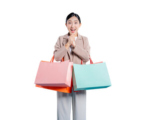A delightfully surprised young Asian woman holds shopping bags with her hands clasped together near...