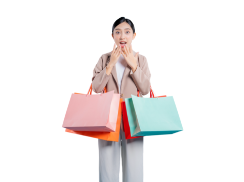 An amazed young Asian woman holding shopping bags covers her mouth with her hands in shock and disbelief, reacting to an unbelievable sale or surprising news, on a png background.
