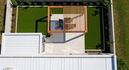 Aerial view of modern backyard design with pergola artificial grass and white patio for outdoor living