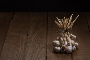 A bunch of garlic on a dark wooden background. Graphic resources.