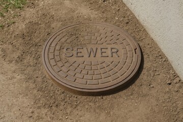 Soil-covered underground access point adjacent to a building with a road drain cover