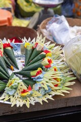 Balinese offerings, called Canang Sari, are displayed on a tray for sale at a market in Ubud, Bali,...
