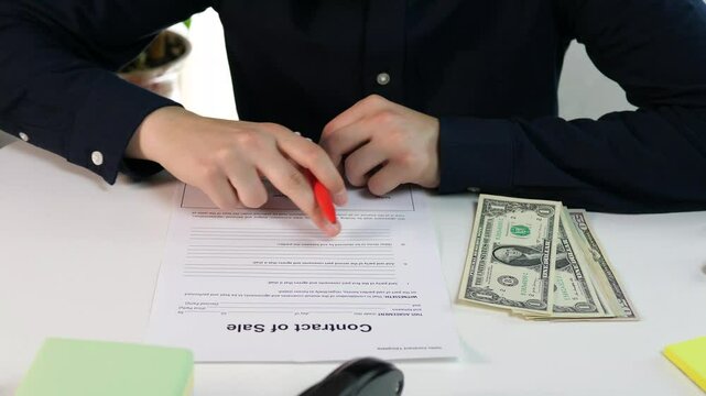 Client with money and sales contract form, studying and reading it before signing. Sales and deliveries.