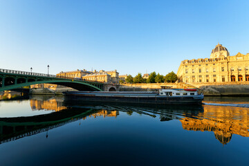 Barge on the Seine river and Notre-Dame bridge in the 4th arrondissement of Paris city
