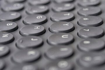 Close up of black round keyboard keys with alphabet and numerals.