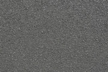Close-up of weathered asphalt with gritty surface texture, top-down perspective