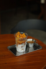 Closeup of Iced Caramel Macchiato at the coffee shop, Caramel Macchiato is a classic macchiato beverage. It consists of vanilla syrup, espresso, steamed milk, foam, and caramel drizzle