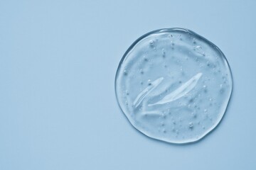 Clear hyaluronic acid gel displayed against a blue backdrop with blank space for messaging
