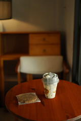 A cup of ice amaricano and bakery on the wood table