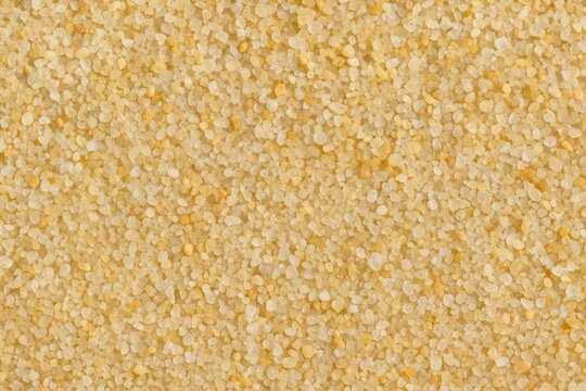 Close-up of textured coarse sand particles on a tropical-themed backdrop