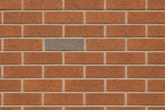 Brick wall featuring a single gray brick among brown bricks
