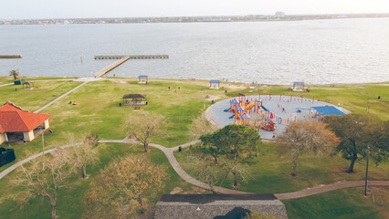 Public pavilion with red roof located near lakefront colorful playground for shade and social...