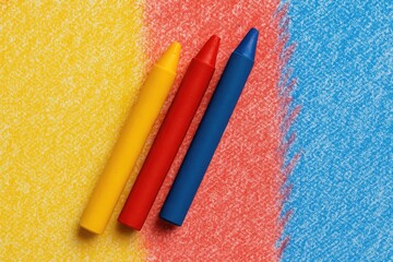 Set of three colorful crayons in yellow, red, and blue hues