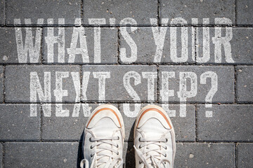 What’s Your Next Step? Decision Making Concept with Sneakers Standing on Pavement