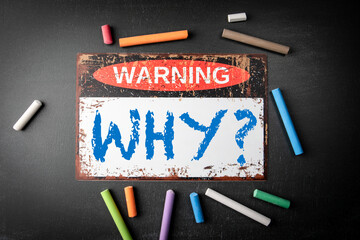 Questioning Concept with Warning Sign and Chalks Emphasizing the Word “Why” on Blackboard