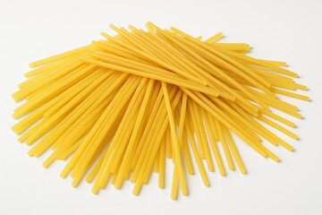 Uncooked dry pasta pieces on a plain white backdrop