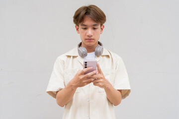 Non binary cute Asian young gay man using phone