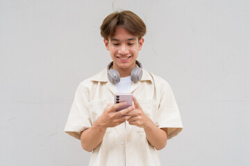 Non binary cute Asian young gay man using phone
