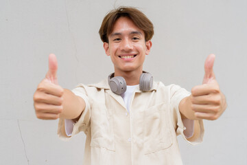 Non binary person giving thumbs up and smiling