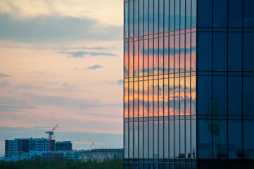 sunset in the city reflected on a glass facade of building