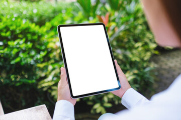 Mockup image of a woman holding digital tablet with blank white desktop screen in the nature outdoors