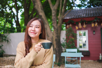Portrait image of a woman drinking coffee in the outdoors cafe